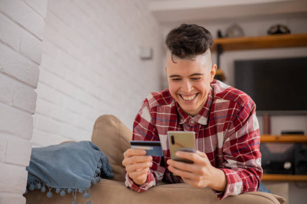istock Cheerful  woman doing online shopping 1500141559