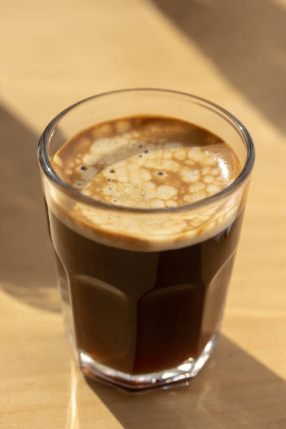 istock Three espresso coffees on a wooden board with shadow play. 1500151499