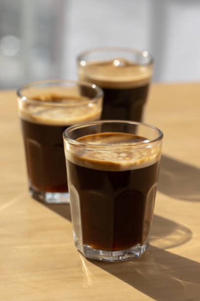 istock Three espresso coffees on a wooden board with shadow play. 1500151517