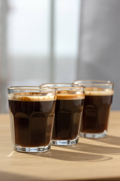 istock Three espresso coffees on a wooden board with shadow play. 1500151552