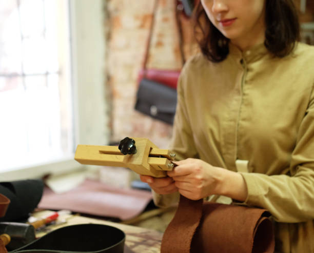 istock young brunette woman works in a bag making studio, cuts out details 1500155946