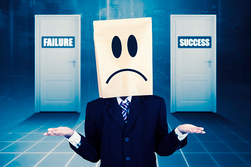 Clueless businessman standing in front of success and failure doors