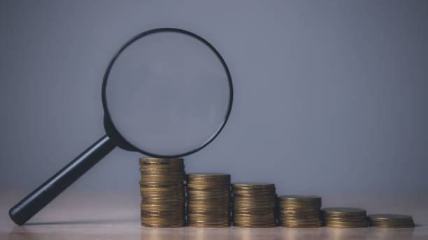 istock Growing stacks of coins with magnifying glass. 1500176494