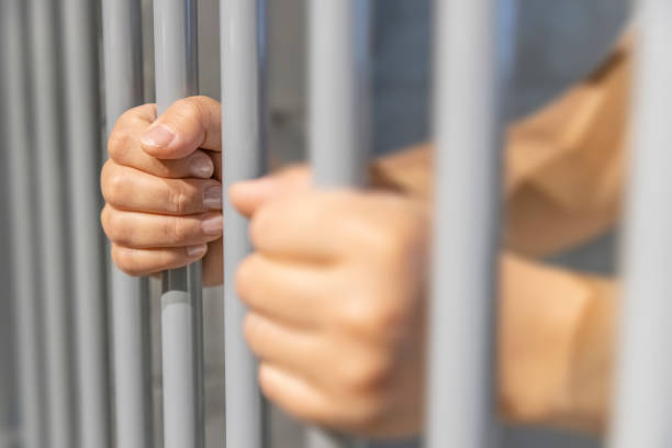 istock A person behind bars on a jail cell incarcerated 1500176597