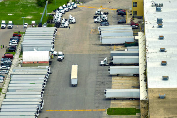 istock Big corporate shipment center with many cargo semi trucks unloading and uploading retail products for further retail shipment. Global market concept 1500177188