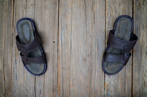 brown leather slippers on wood background,top view