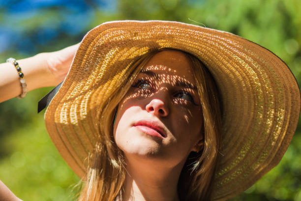 Young woman protecting herself from sun on summer day.