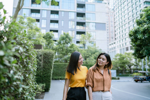 istock Two Asian Women Taking Evening Stroll While Going Home Together. 1500191084