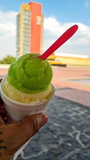 GREEN LEMON SNOW ON THE CAMPUS OF CIUDAD UNIVERSITRARIA WITH BLURRED BACKGROUND OF THE RECTORY TOWER OF THE AUTONOMOUS UNIVERSITY OF MEXICO UNAM