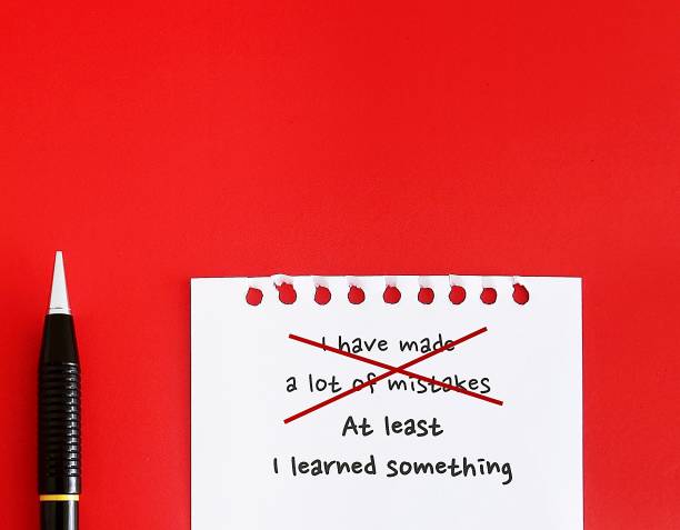 On red copy space background, pencil writing on paper I HAVE MADE A LOT OF MISTAKES, replaced with AT LEAST I LEARNED SOMETHING - to challenge pessimistic self-talk by reframe negative thoughts to positive thinking and increase self-confidence en el fondo de espacio de copia roja, escritura a lápiz en papel he cometido muchos errores, reemplazado por al menos aprendÍ algo - desafiar el diálogo interno pesimista replanteando los pensamientos negativos en pensamiento positivo y aumentar la conf