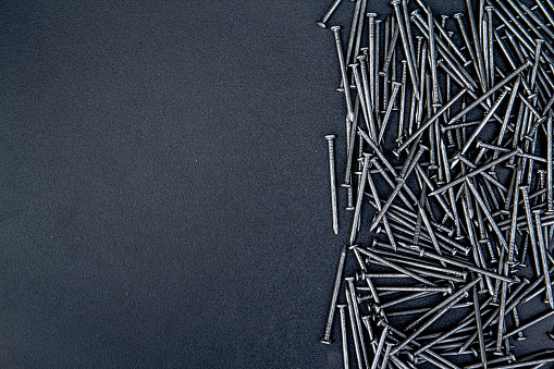 Close up of carpentry nails on black background with copy space