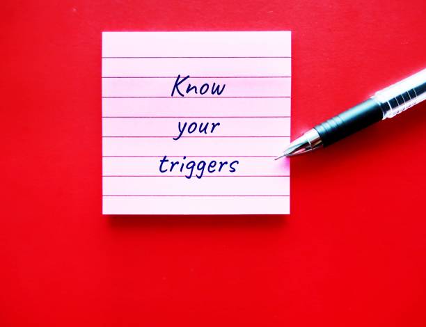 istock On red background, pen writing on note pad KNOW YOUR TRIGGERS, learning to know experience of having emotional reaction to a disturbing topic in the media or social setting and empower to cope with it 1500210929