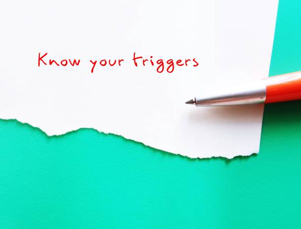 On green copy space background, pen writing on torn paper KNOW YOUR TRIGGERS, learning to know experience of having emotional reaction to a disturbing topic (such as violence in the media or social setting and empower to cope with it en el fondo del espacio de copia verde, escribir con lápiz en papel rasgado conozca sus desencadenantes, aprender a conocer la experiencia de tener una reacción emocional a un tema perturbador (como la violencia en los medios de comunicación o el entorn