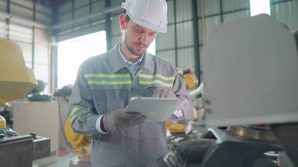istock Industrial  engineer check the quantity of the machine parts and confirm workpiece on tablet in robot manufacturing plant. Male technician wearing safety uniform working in robotic arm production line, inspection the quality before shipping at factory. 1500212489