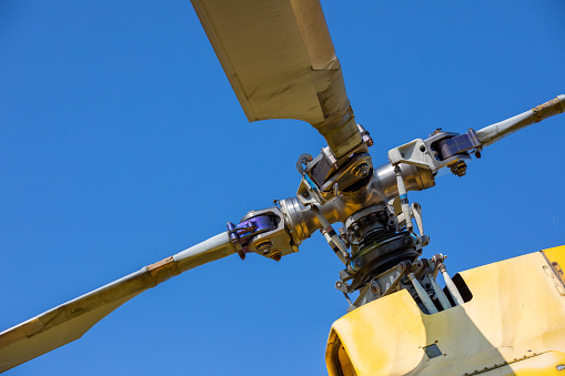 Vintage Charm: The Weathered Rotors of a Yellow Old Helicopter Unveil Aviation History