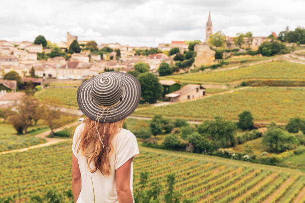 Rear view of woman looking at green vineyard in Bordeaux region, Saint Emilion- France, Nouvelle aquitaine stock photo