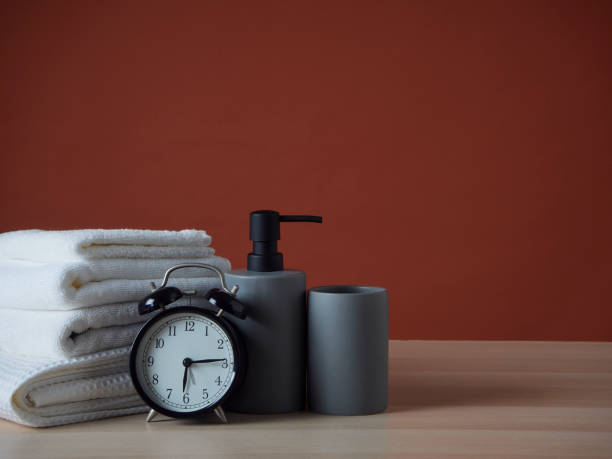 istock Bathroom set with clean towels and alarm clock on the table 1500217928