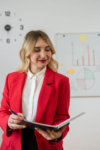 istock Female manager in red suit making presentation with office board flip chart 1500222908