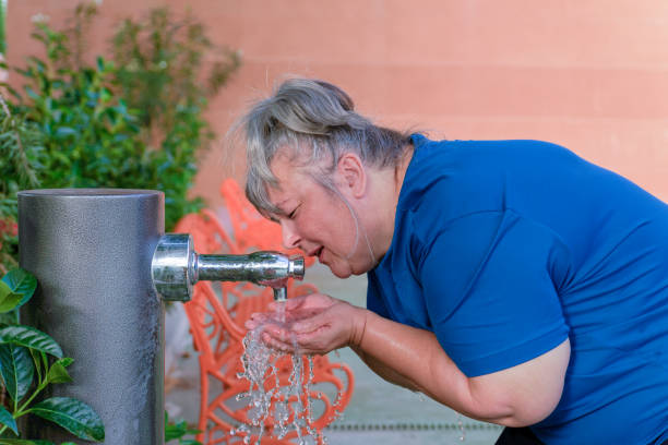 istock elderly woman drinking water from a fountain after exercise 1500222978