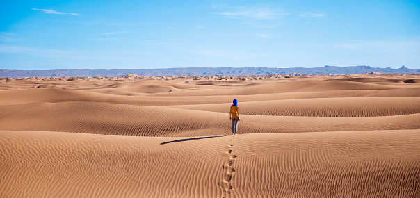 Young woman with a traditional emirati abaya in desert. Abu Dhabi, UAE.