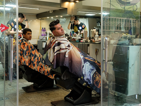Local barbershop in uptown Tehran, Iran. Men are waiting for a haircut.