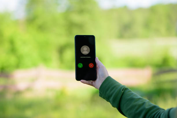 An unknown number calling a mobile phone, displayed on the screen of a smartphone held in a hand