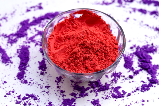 Gulal (Colored Powder) in bowl on white background. Holi is a popular and significant Hindu festival celebrated as the Festival of Colours, Love and Spring. It celebrates the eternal and divine love of the god Radha and Krishna.