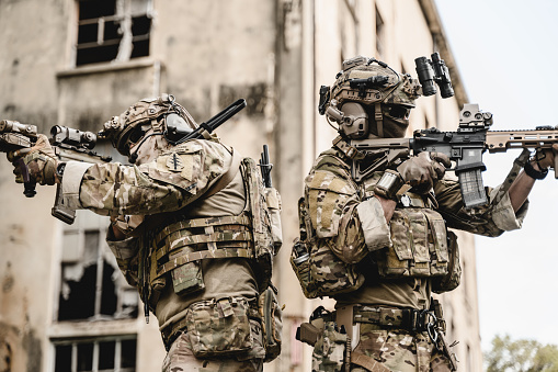 Expert team of soldiers attacking enemy during military operation, Army soldiers in protective combat uniform, Soldiers with rifle on world war field