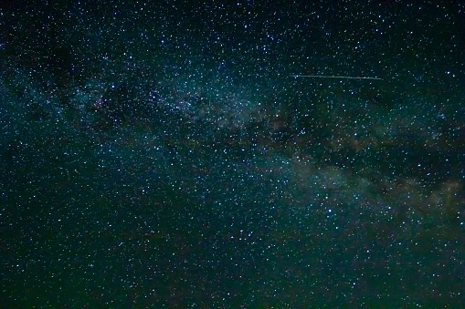 starry night sky with satellite trail