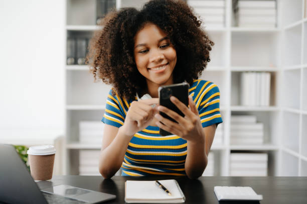 istock Beautiful African woman using laptop and tablet while sitting at her working place. Concentrated at work in home office 1500231307
