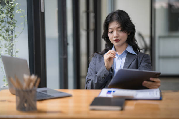 istock Attractive business Asian woman using a digital tablet while sitting at a workplace desk in an office. 1500233013