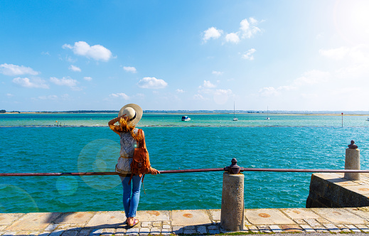 Woman standing looking at panoramic view of Altanic ocean coast and boats-  ( Le croisic)Pays de la Loire,  Loire Atlantic