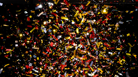 Close-up of exploding confetti against black background.