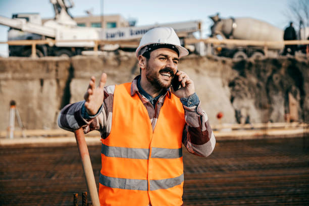 istock A builder is leaning on shovel and having phone call while standing on foundation at site. 1500235448