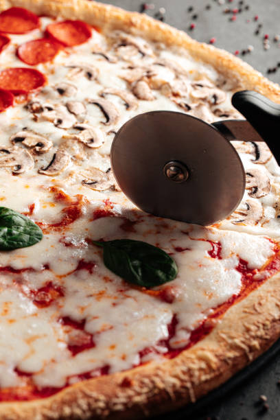 istock Cutting four seasons pizza with special knife 1500237415