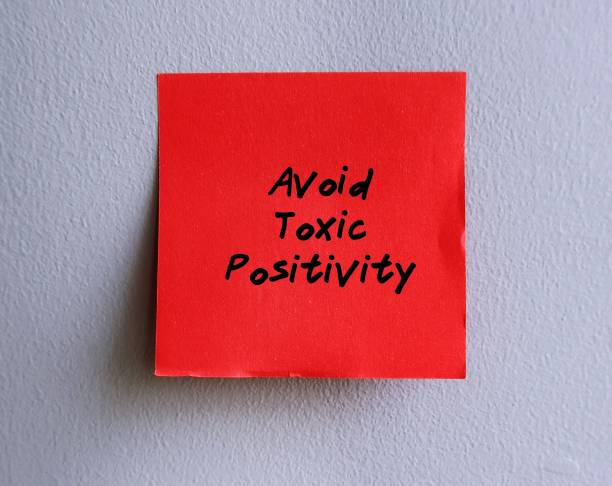istock Red paper note stick on office wall with handwritten text AVOID TOXIC POSITIVITY, means optimistic state across all situations, state of denial or cover up human emotion with positive thoughts 1500238067