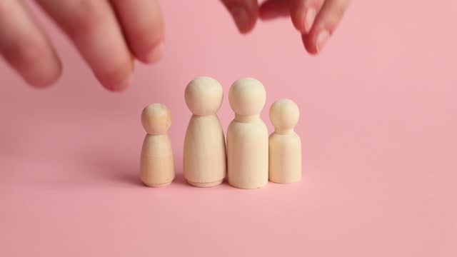 Wooden figurines of young family with children planning