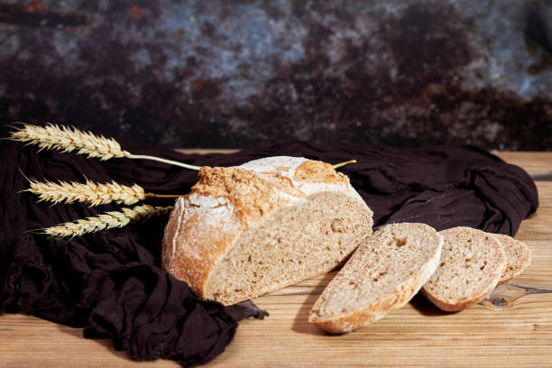 istock Golden bread next to ears of wheat on a table 1500240053