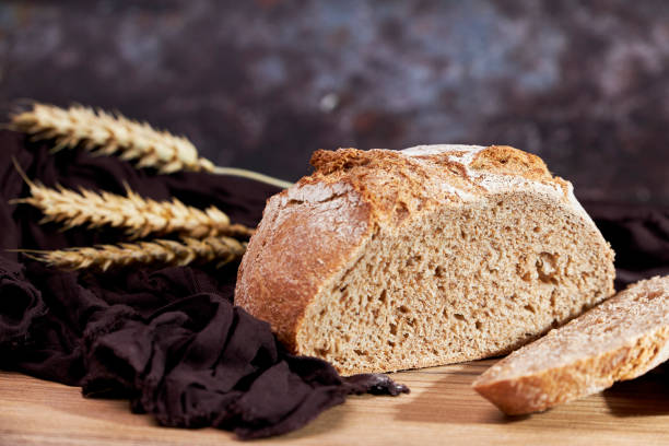 istock Golden bread next to ears of wheat on a table 1500240061