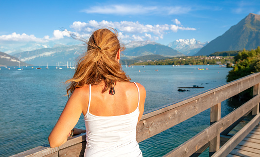 Woman tourist in Switzerland,  Thun lake with alps mountain in the background