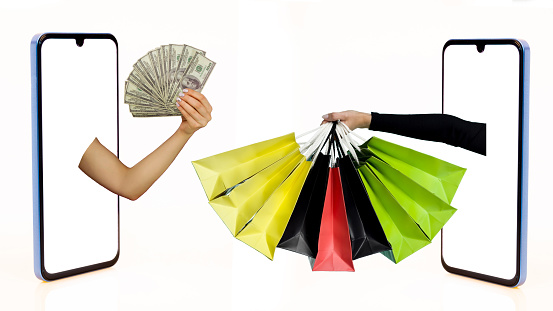 Two Hands outstreched from from different smartphone screen one with dollar bills, the other with shopping bags, white background, isolated. Creative image for delivery service mobile application concept