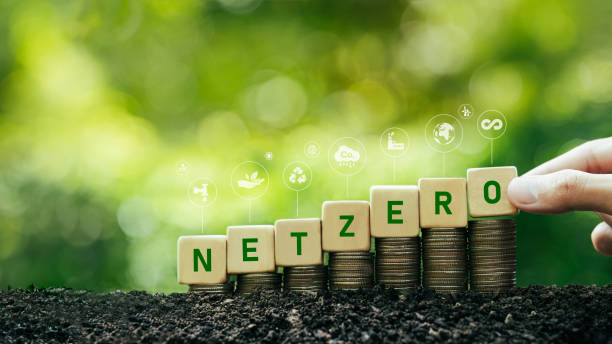 istock net zero and carbon neutral concept Zero net greenhouse gas emissions target Weather neutral long term strategy. Green net zero text on wooden blocks and lots of floating icons. green background 1500242186