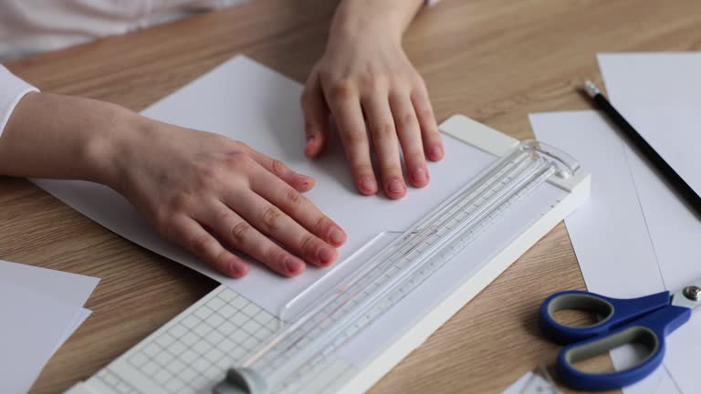 Office worker using manual paper cutter or paper cutter