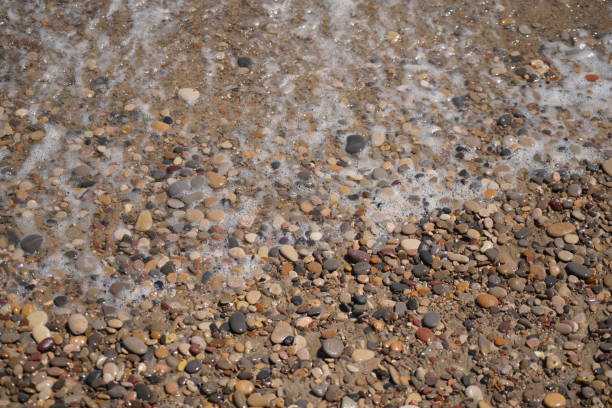 waves on mediterranean sea with pebble beach and green water