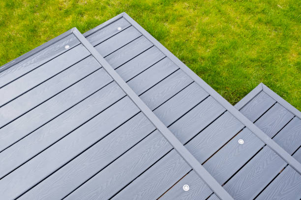 Newlly constructed decking over two levels with deck lighting installed and in Ash grey colour with summer house painted in the same matching colour.Good Image for a landscape Gardiner Ash grey composite decking on a rainy wet day showing the full grain of the decking boards A good background image decking stock pictures, royalty-free photos & images