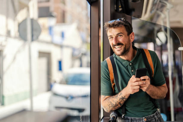 istock A happy man with phone is using public transportation while standing next to the window. 1500246820