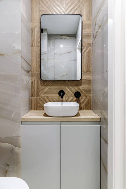 istock Modern bathroom with black fixtures, mirror and white sink 1500254501