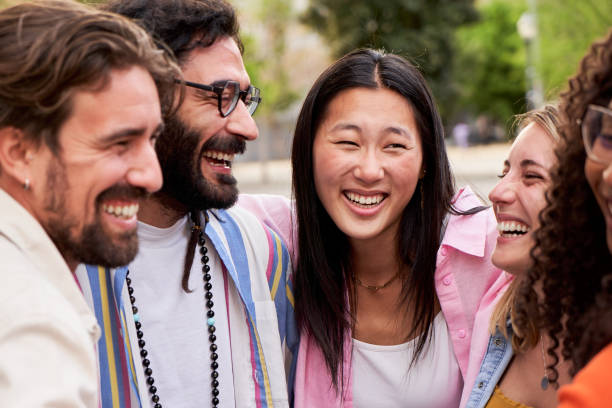 istock Multicultural group of friends looking at each other smiling while embracing in circle outdoors. 1500256024