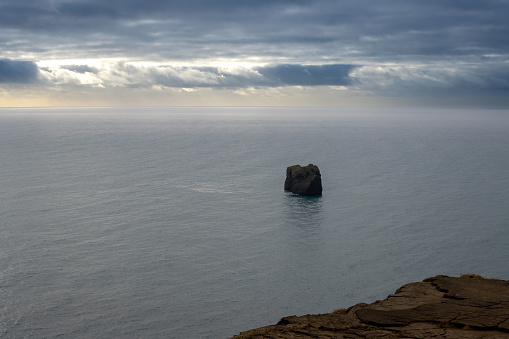 Coastline of the Atlantic ocean on the south of the island. Famous beach with black sand with its rock formations. Cloudy sky in the autumn. Reynisfjara, Iceland.