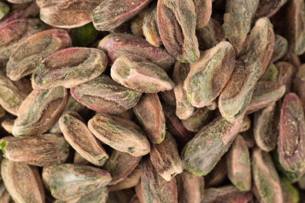 istock Peeled pistachio nuts heap isolated on white background 1500264930